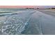 Calm surf on a sandy beach with clear water and a view of the city skyline in the distance at 1180 Gulf Blvd # 1201, Clearwater, FL 33767