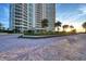 Elegant condo building featuring lush landscaping and a paver drive entrance at 1180 Gulf Blvd # 1201, Clearwater, FL 33767
