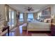 Main bedroom featuring a ceiling fan, wood floors, water views, and balcony access at 1180 Gulf Blvd # 1201, Clearwater, FL 33767