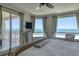 Main bedroom featuring water views, a ceiling fan, and balcony access at 1180 Gulf Blvd # 1201, Clearwater, FL 33767