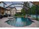Relaxing screened-in pool area with a waterfall feature and ample patio space at 12239 Crestridge Loop, Trinity, FL 34655