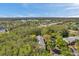 Aerial view displays the condo complex bordered by dense trees near a highway for ease of access at 1398 Shady Pine Way # H2, Tarpon Springs, FL 34688