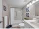 Bright bathroom featuring a shower-tub combo, white fixtures, and stylish blue-themed decor at 1398 Shady Pine Way # H2, Tarpon Springs, FL 34688