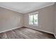 Neutral bedroom with hardwood floors and a sunny window for natural light at 1398 Shady Pine Way # H2, Tarpon Springs, FL 34688