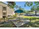 A picnic area with table and umbrella is located on the landscaped grounds at 1398 Shady Pine Way # H2, Tarpon Springs, FL 34688