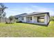 An overview of the backyard features a covered patio, green grass, and a white fence at 14180 Samoa Hill Ct, Riverview, FL 33569