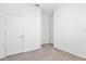A bright bedroom with neutral carpet, white walls, and a door at 14180 Samoa Hill Ct, Riverview, FL 33569