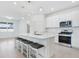 Beautiful kitchen with stainless steel appliances, a large center island with bar stools, and bright, modern lighting at 14180 Samoa Hill Ct, Riverview, FL 33569