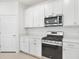 Kitchen with white cabinetry, stainless steel appliances, and white countertops at 14180 Samoa Hill Ct, Riverview, FL 33569