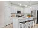 Bright kitchen features white cabinetry, stainless steel appliances, island with breakfast bar, and pendant lighting at 14180 Samoa Hill Ct, Riverview, FL 33569