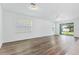 Bright living room boasts hardwood floors, large windows, and a sliding glass door to the outdoor space at 14180 Samoa Hill Ct, Riverview, FL 33569