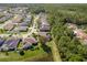 Aerial view of a suburban neighborhood with lush green trees and a nearby lake at 14709 Coral Berry Dr, Tampa, FL 33626