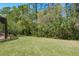 Large, grassy backyard with lush greenery provides ample space for recreation and relaxation at 14709 Coral Berry Dr, Tampa, FL 33626