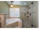 Bathroom with a luxurious soaking tub and separate tiled shower with a glass enclosure at 14709 Coral Berry Dr, Tampa, FL 33626