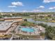 Aerial view of a community pool with lounge chairs and umbrellas alongside a river on a clear, sunny day at 1801 Bedford Ter # 221, Sun City Center, FL 33573