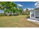 Spacious backyard with a lush green lawn, mature trees, and easy access to outdoor enjoyment at 1801 Bedford Ter # 221, Sun City Center, FL 33573