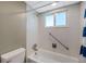 Bathroom featuring white tile walls, shower/tub, grab bar, shower head, and blue striped shower curtain at 1801 Bedford Ter # 221, Sun City Center, FL 33573