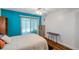 Bedroom features wood-look floors, an accent teal wall, and a sliding door to the patio at 1801 Bedford Ter # 221, Sun City Center, FL 33573