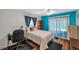 Bedroom with white walls and accent teal wall, complete with fan, desk, and wood-look floors at 1801 Bedford Ter # 221, Sun City Center, FL 33573
