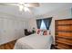 Neutral bedroom with wood-look floors, fan, desk, bookcase, closet, and a bright window at 1801 Bedford Ter # 221, Sun City Center, FL 33573