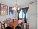 Dining area with a wooden table, chairs, and a view of the window with dark curtains at 1801 Bedford Ter # 221, Sun City Center, FL 33573
