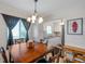 Bright dining area featuring a wooden table with chairs, a chandelier, and view of the kitchen at 1801 Bedford Ter # 221, Sun City Center, FL 33573