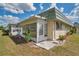 Rear exterior view of a single-story home with a porch, small patio, and well-kept lawn at 1801 Bedford Ter # 221, Sun City Center, FL 33573