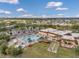 Scenic aerial view of community pool and amenities. Surrounded by mature trees and lush landscaping on a bright, sunny day at 1801 Bedford Ter # 221, Sun City Center, FL 33573