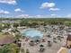 Aerial view of a community pool featuring lounge chairs, umbrellas, and tables with seating on a beautiful pool deck at 1801 Bedford Ter # 221, Sun City Center, FL 33573
