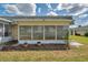 Exterior view of an enclosed porch featuring a wall of windows and tidy landscaping at 1801 Bedford Ter # 221, Sun City Center, FL 33573
