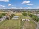Overhead shot shows lawn bowling courts and manicured lawns, with community amenities, under a bright, sunny sky at 1801 Bedford Ter # 221, Sun City Center, FL 33573