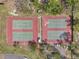 Overhead aerial view of four well-kept tennis courts in a community setting, surrounded by lush landscaping and trees at 1801 Bedford Ter # 221, Sun City Center, FL 33573