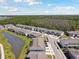 Aerial shot of townhome community with lake and forest at 1869 Hovenweep Rd, Wesley Chapel, FL 33543