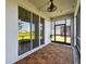 Relaxing screened balcony with tile flooring and views of lush green landscape at 1869 Hovenweep Rd, Wesley Chapel, FL 33543