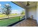 Charming balcony with wood tiles and tranquil views of the pond and landscape at 1869 Hovenweep Rd, Wesley Chapel, FL 33543