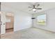 Inviting bedroom with natural light, neutral carpet, and access to the en-suite bathroom at 1869 Hovenweep Rd, Wesley Chapel, FL 33543