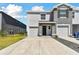 This home has an attached garage, black front door, and manicured yard at 1869 Hovenweep Rd, Wesley Chapel, FL 33543