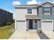 This home has an attached garage, black front door, and manicured yard at 1869 Hovenweep Rd, Wesley Chapel, FL 33543