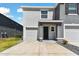 This home has an attached garage, black front door, and manicured yard at 1869 Hovenweep Rd, Wesley Chapel, FL 33543