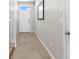Neutral paint, ceramic tile hallway leads to front door, with stairs to upper level at 1869 Hovenweep Rd, Wesley Chapel, FL 33543