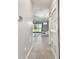 Hallway features a view of the living room through large sliding glass doors and a decorative chandelier at 1869 Hovenweep Rd, Wesley Chapel, FL 33543