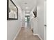 Hallway with neutral paint, ceramic tile flooring, staircase and mirror on wall at 1869 Hovenweep Rd, Wesley Chapel, FL 33543