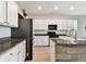 Kitchen featuring granite countertops, white cabinets, black appliances, and tile flooring at 1869 Hovenweep Rd, Wesley Chapel, FL 33543