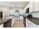 Bright kitchen features tile floors, granite countertops, stainless-steel refrigerator, and white cabinetry at 1869 Hovenweep Rd, Wesley Chapel, FL 33543