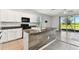 Kitchen with white cabinets, granite countertops, black appliances, and center island with a wood panel accent at 1869 Hovenweep Rd, Wesley Chapel, FL 33543