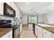Open-concept kitchen features granite countertops, white cabinetry, and stainless-steel appliances at 1869 Hovenweep Rd, Wesley Chapel, FL 33543