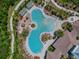 Aerial view of stylish resort-style pool featuring palm trees, lounge chairs, and a clubhouse at 1869 Hovenweep Rd, Wesley Chapel, FL 33543