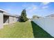 Backyard features a well-maintained lawn, a privacy fence, and mature trees at 200 Fairmont Dr, Spring Hill, FL 34609