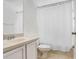 Standard bathroom with white sink, toilet, cabinets, and white shower curtain at 20631 Great Laurel Ave, Tampa, FL 33647