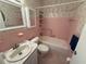 Retro pink bathroom features a tub/shower combo, vanity with sink, and matching pink tile at 2428 Columbia Dr # 72, Clearwater, FL 33763